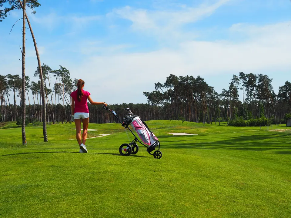 Golfer walking fairway uphill