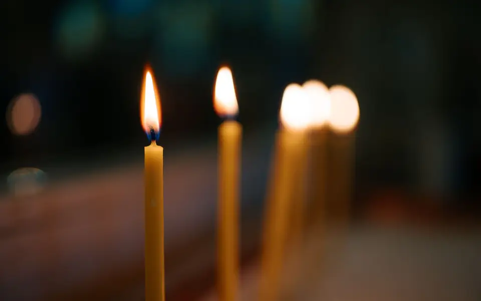 Pillar candles on a mantel in warm light