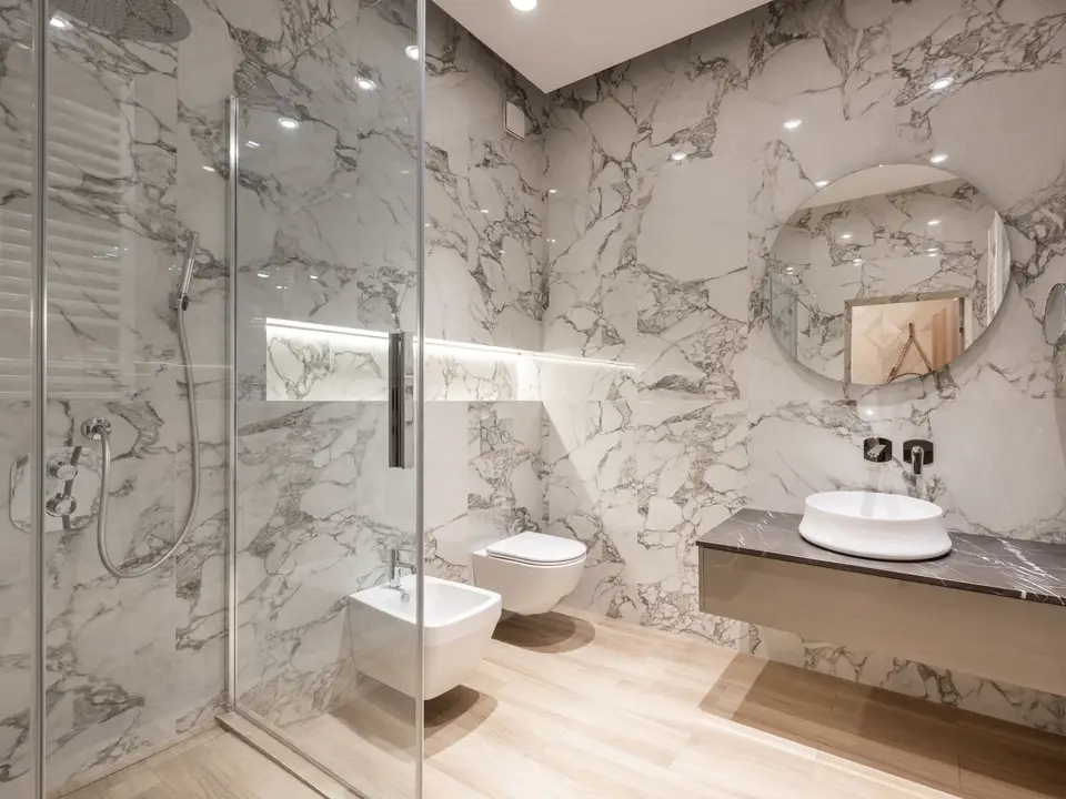 Tiled shower with a recessed niche and a frameless glass panel