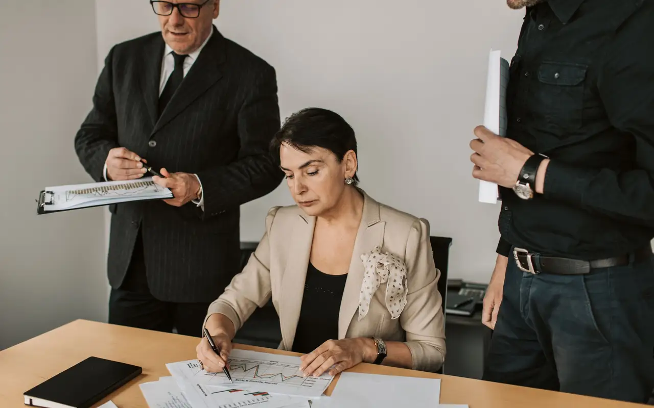 Investment professionals reviewing portfolio charts across a conference table