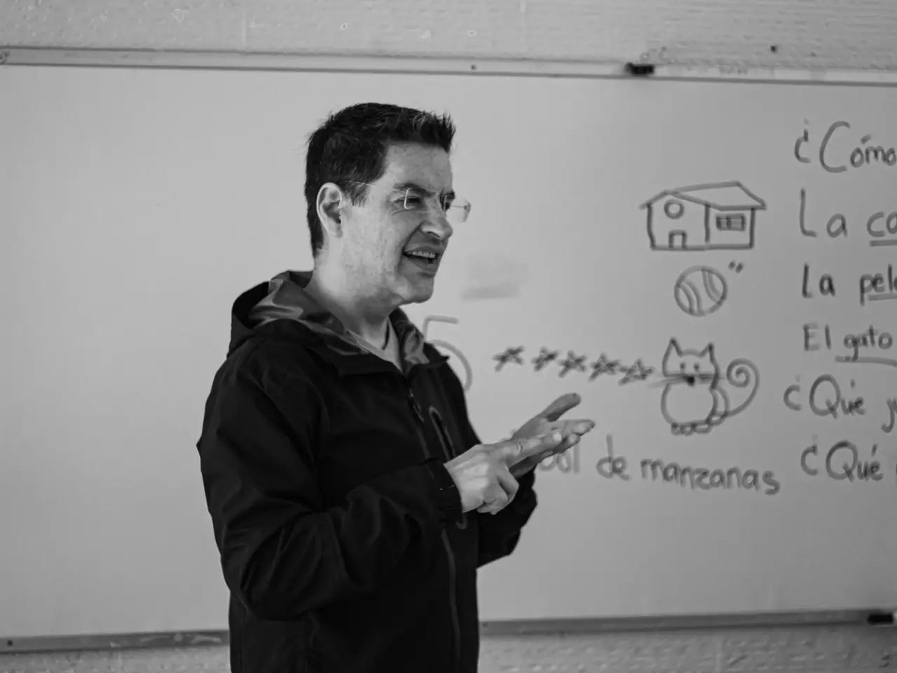 Spanish teacher explaining language concepts on a whiteboard
