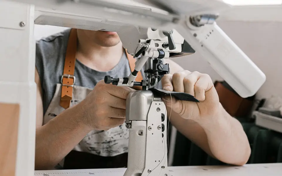 Artisan cutting leather at a workbench