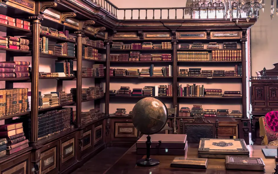 Antique library with wooden bookshelves and a globe