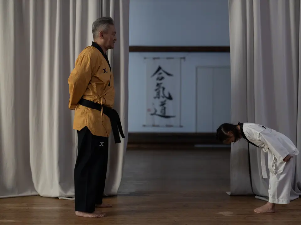 Children in karate uniforms bowing