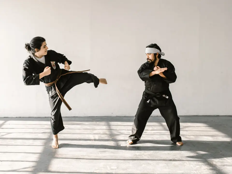 Teen practicing karate kick on pad