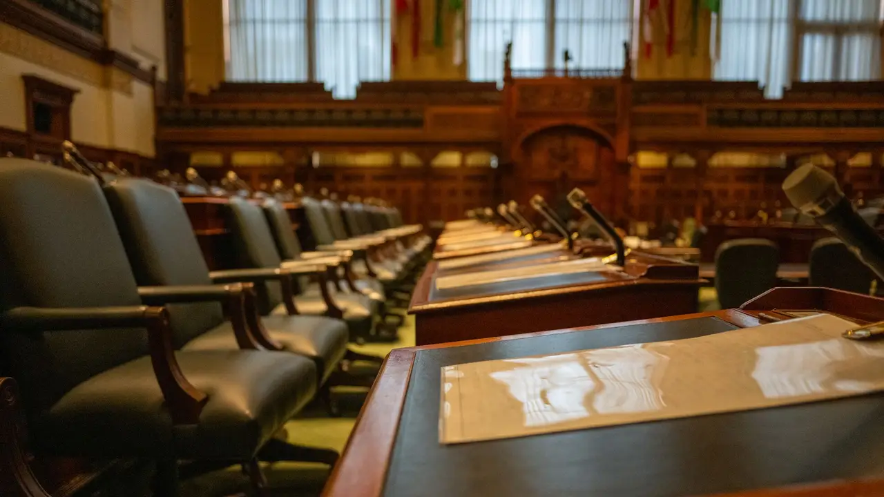 Council chamber with rows of desks and microphones