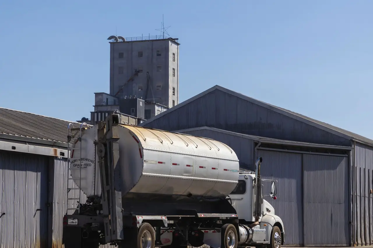 Delivery trucks backed against warehouse loading doors at dawn