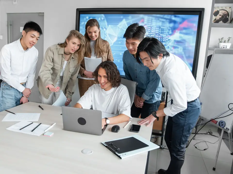 Group of young professionals collaborating around a laptop