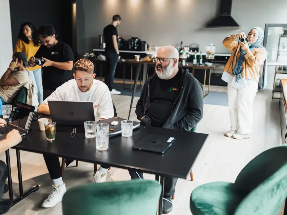 Adults working together with laptops and drinks at a meetup