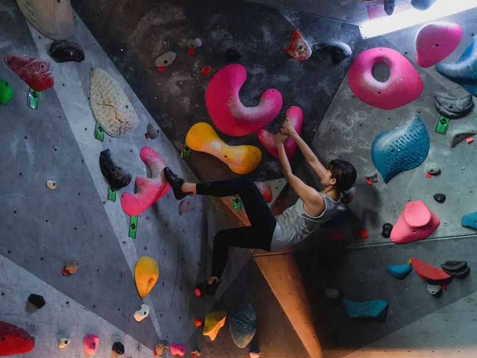 Climber reading a bouldering route on an indoor wall.