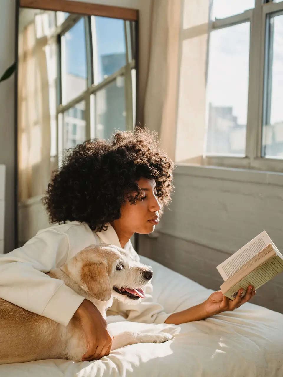 A sitter relaxing on the sofa with a client's dog after a visit