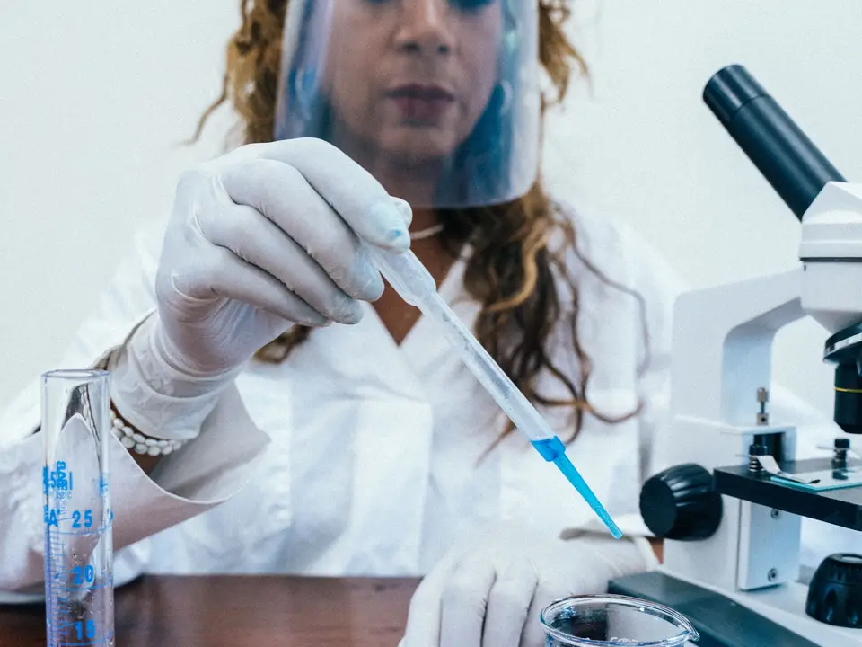 Researcher writing a protocol on a clipboard beside lab equipment