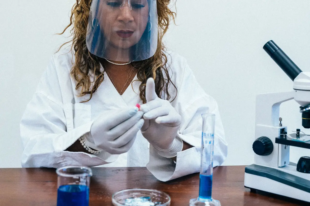 Scientist pipetting liquid into a multiwell plate at a lab bench