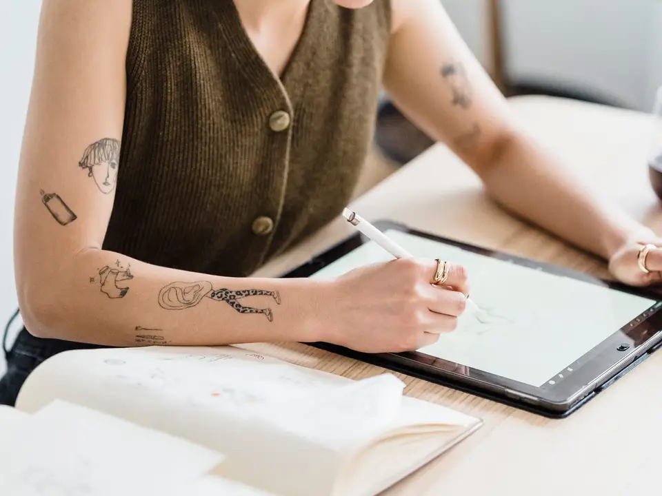 Planner and tablet with circled dates on a sunny desk