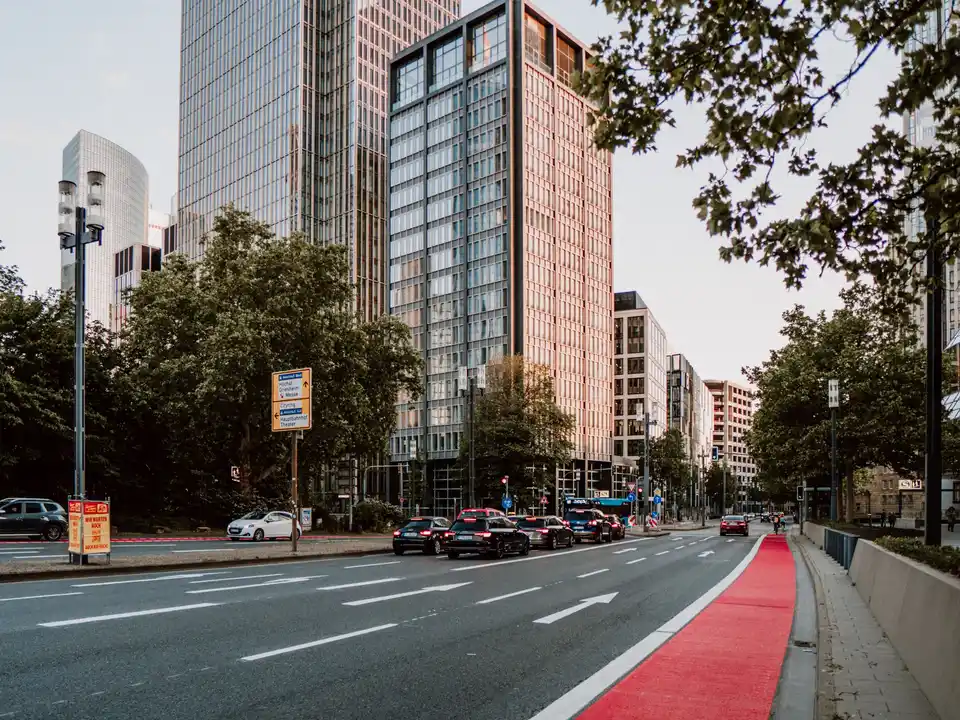 Urban boulevard with a red cycle lane and trees