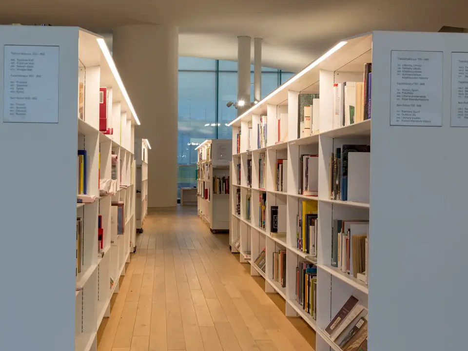 Bright reading aisle between white library shelves