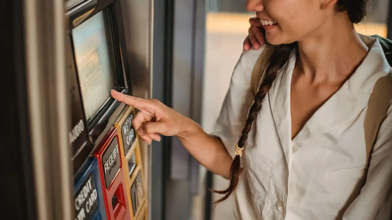 Traveller buying a ticket at a touchscreen machine