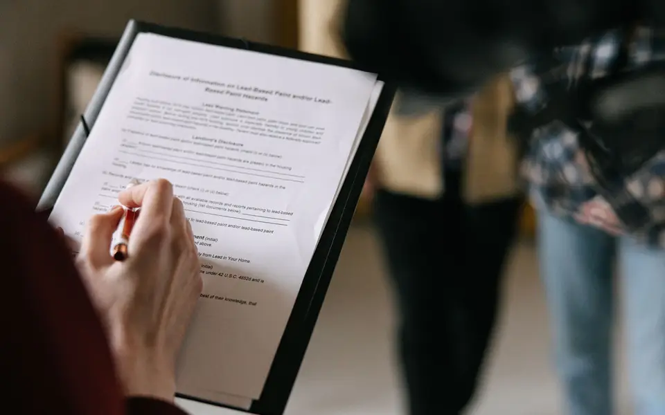 Couple reviewing offer paperwork with a real estate agent indoors