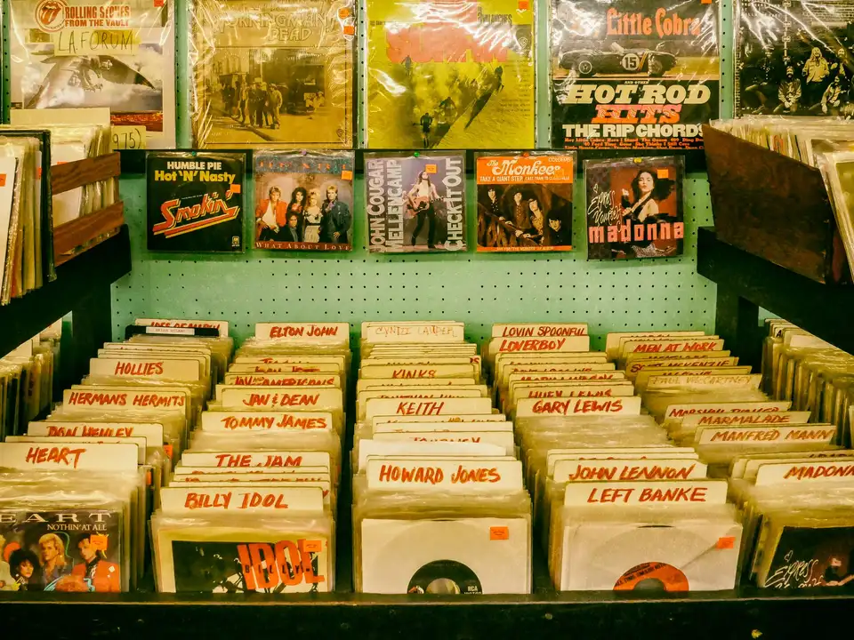 Bins of vinyl records with yellow dividers in a record store