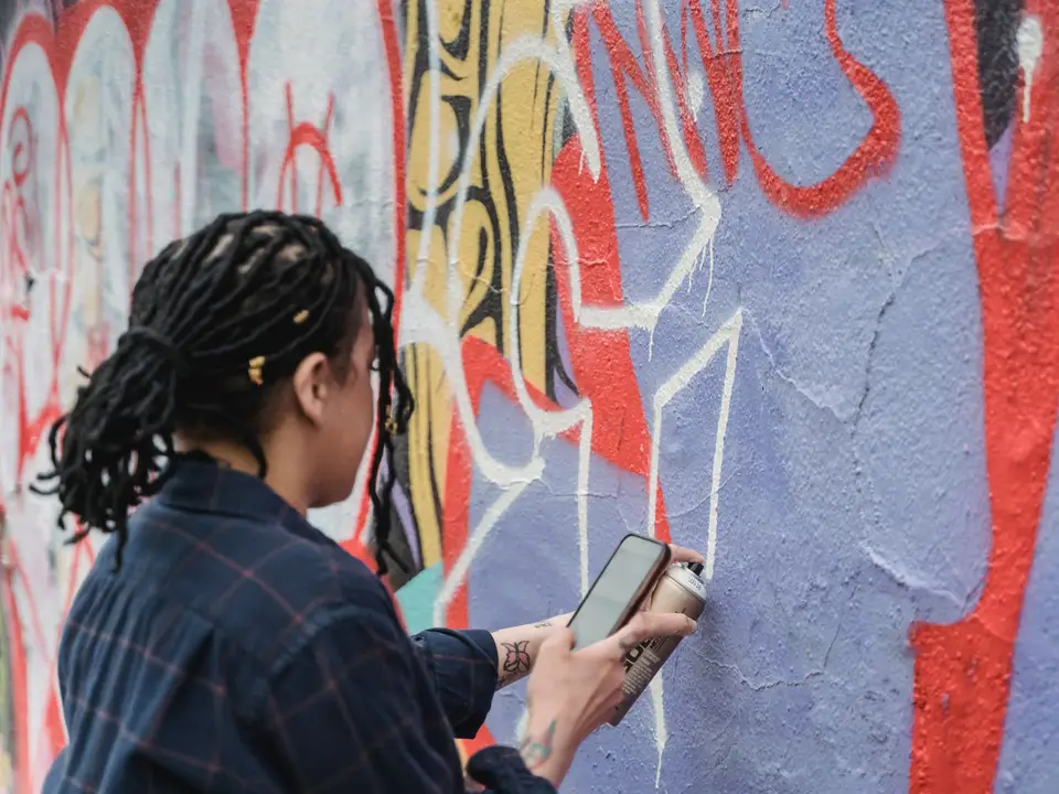 Artists painting a brick wall mural