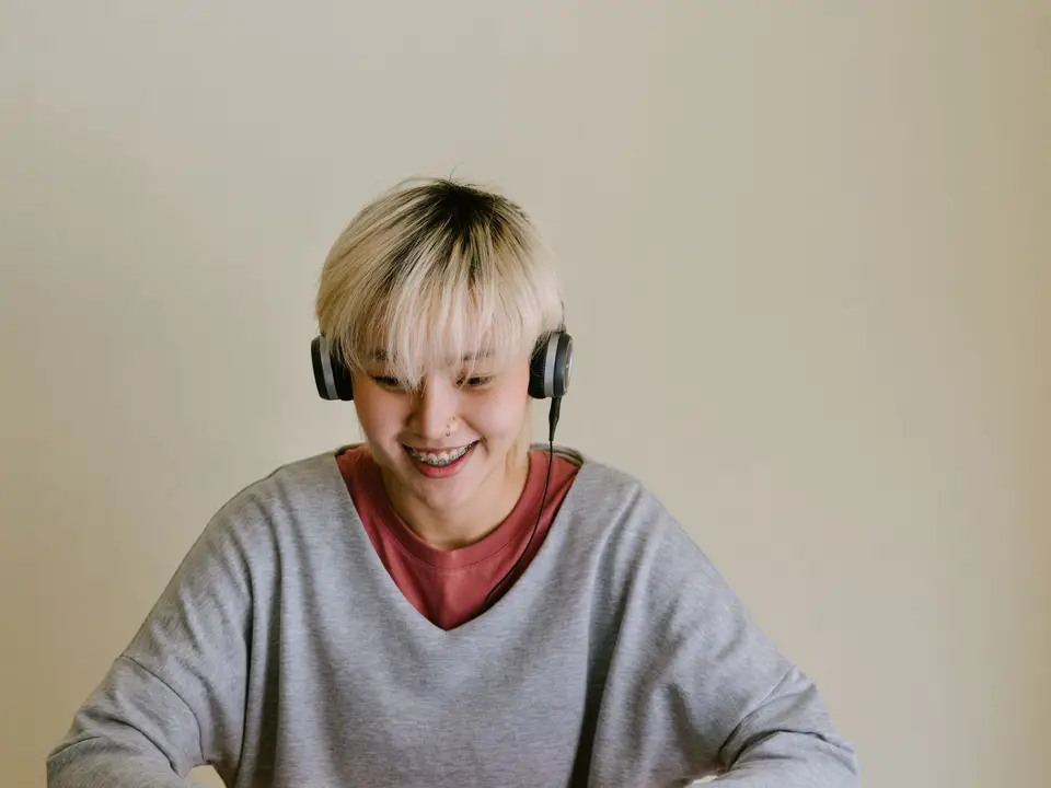 Woman on a video call with headphones on a laptop