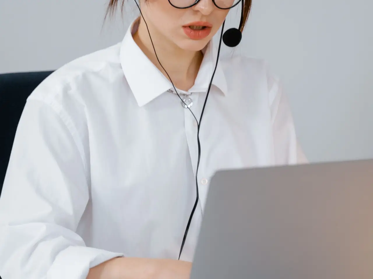 Support specialist in a headset answering questions at a desk