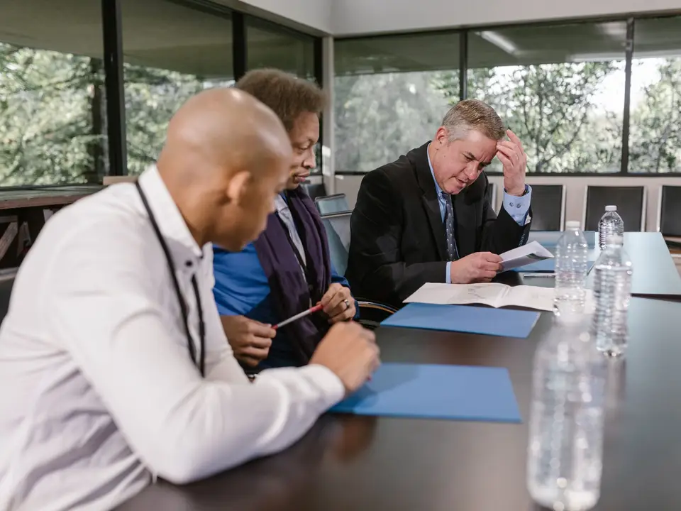 Committee members reviewing documents around a meeting table