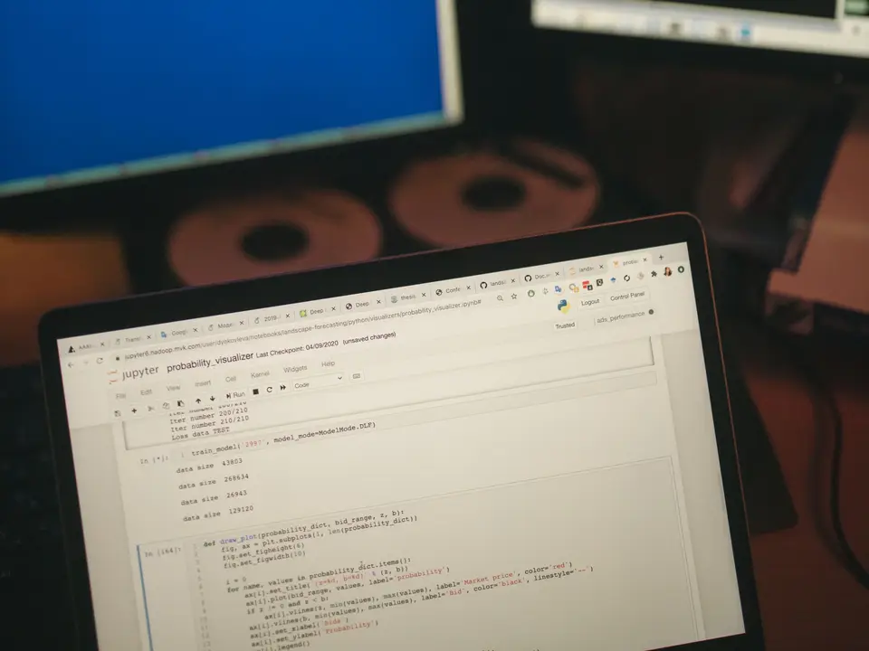 Multi-screen workstation with code on monitors and a laptop