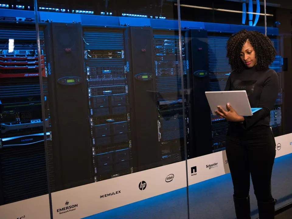 Engineer using a laptop in a server room