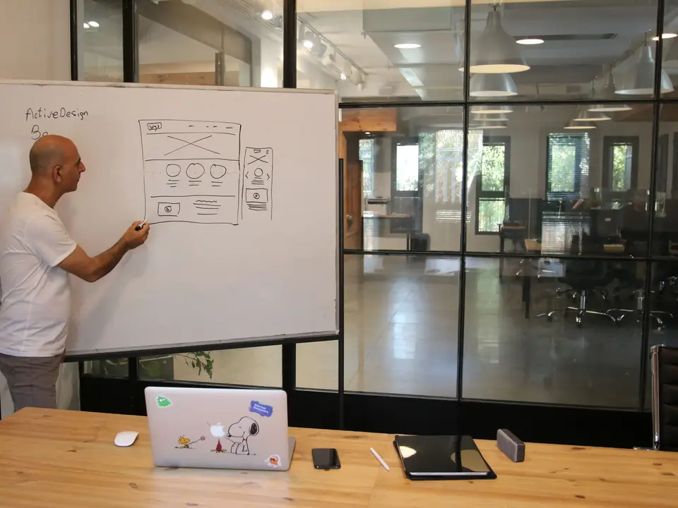 Engineer sketching a system diagram on a whiteboard