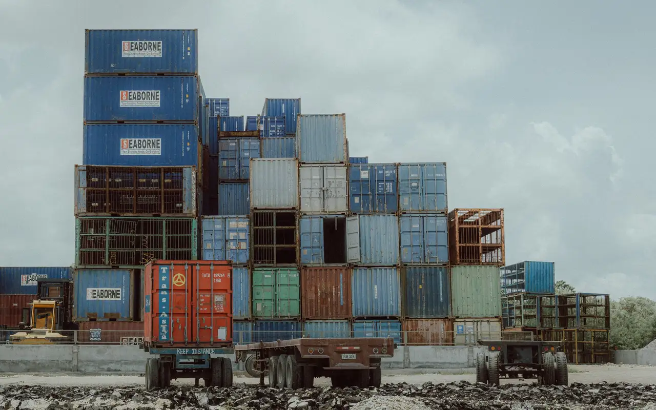 Freight truck beside stacked shipping containers