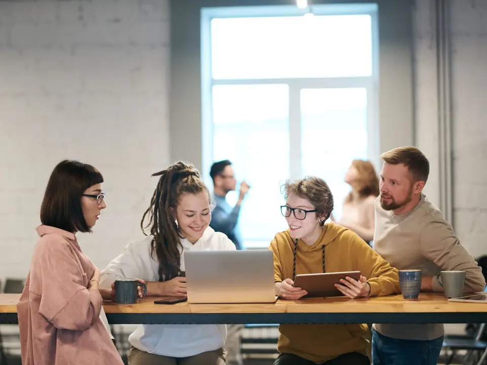 Team reviewing code on a large monitor in an open office