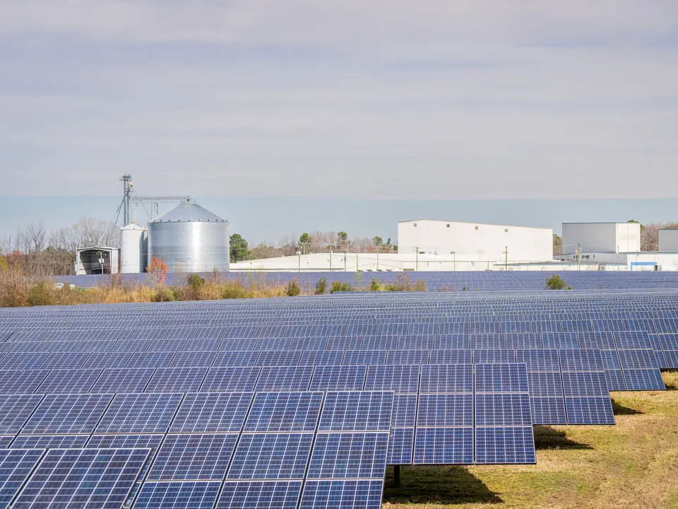 Aerial view of solar panels across farm fields