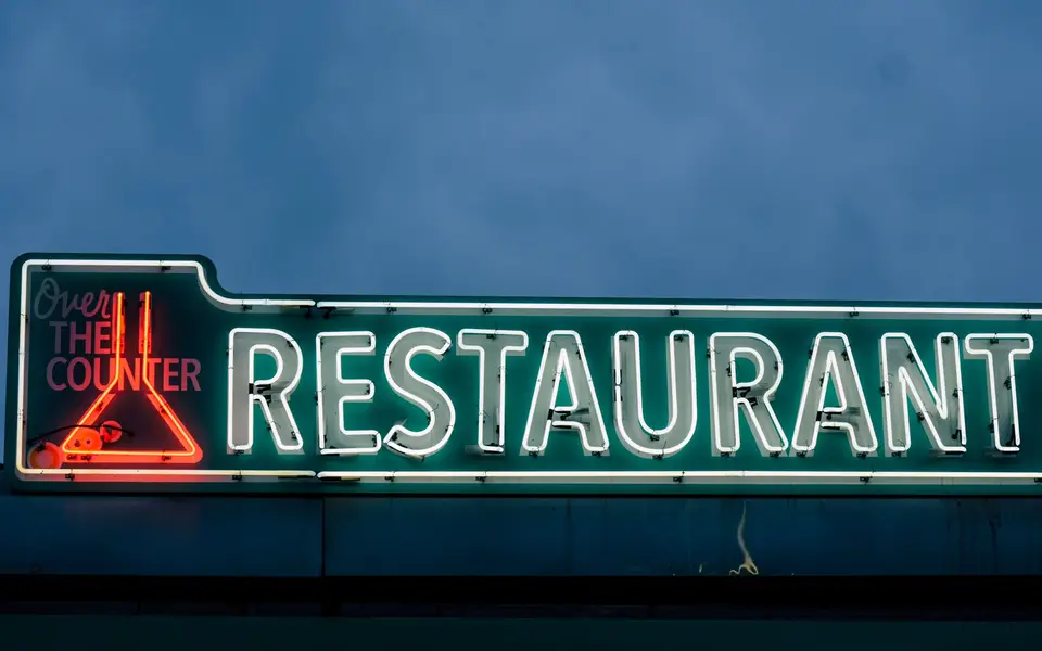 Roadside kitchen sign glowing on the highway at night