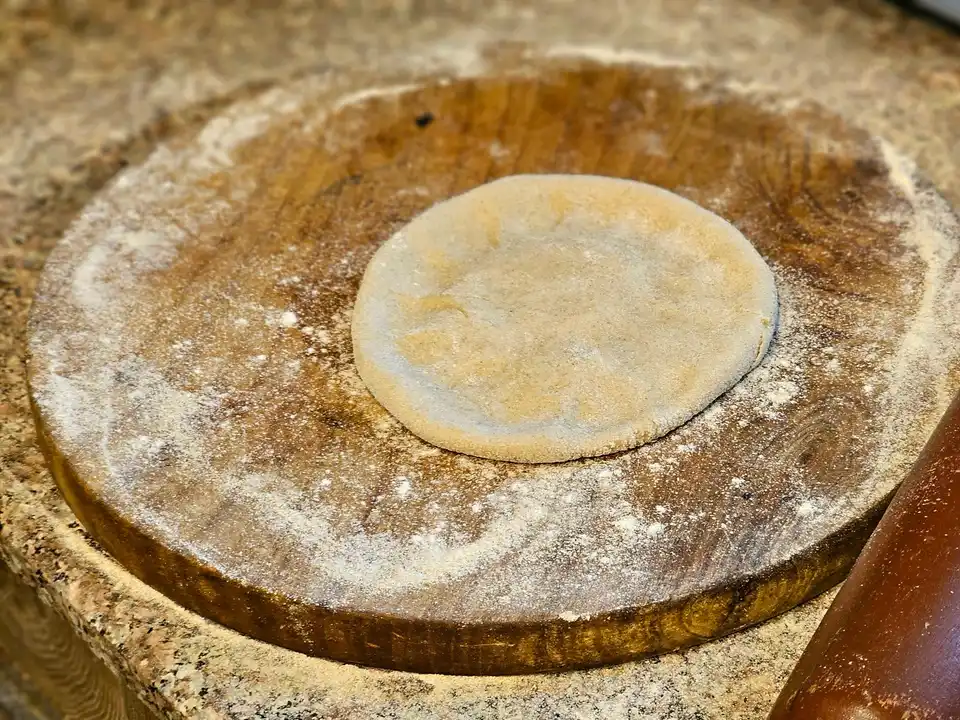 Cook rolling roti on a flour-dusted counter