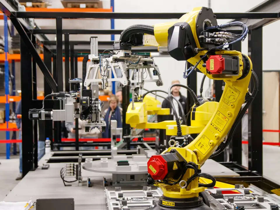 Robot arm stacking parts in a dim workshop at night