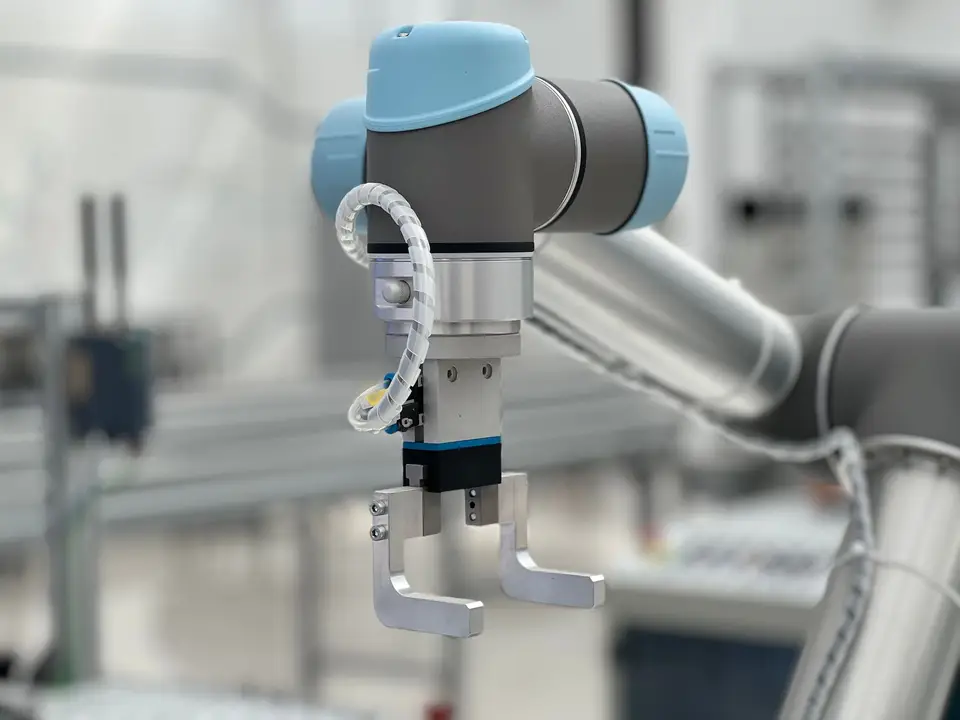 Maker working next to a slow-moving robot arm
