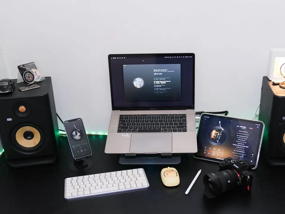 Home studio desk with laptop, tablet, keyboard and two studio speakers