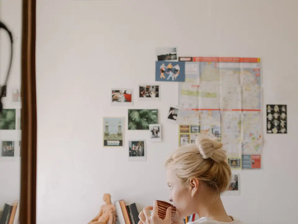 Woman sipping tea in a cozy dorm room