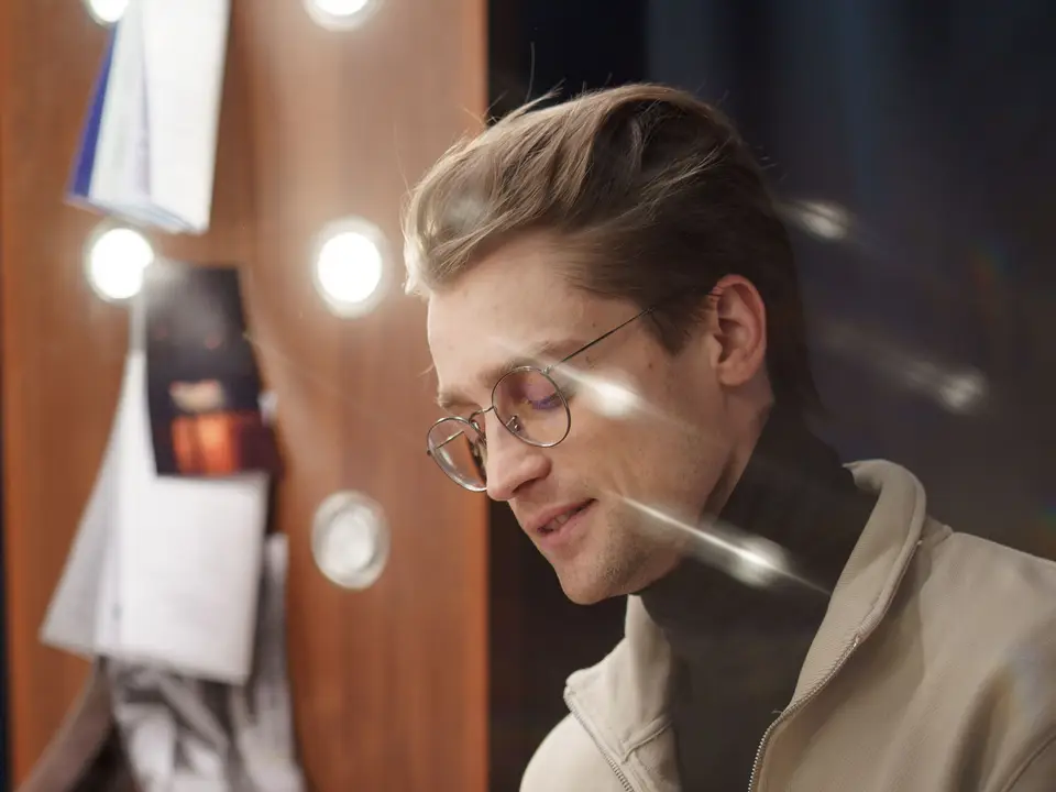 Actor in profile reading a script in a backstage dressing room