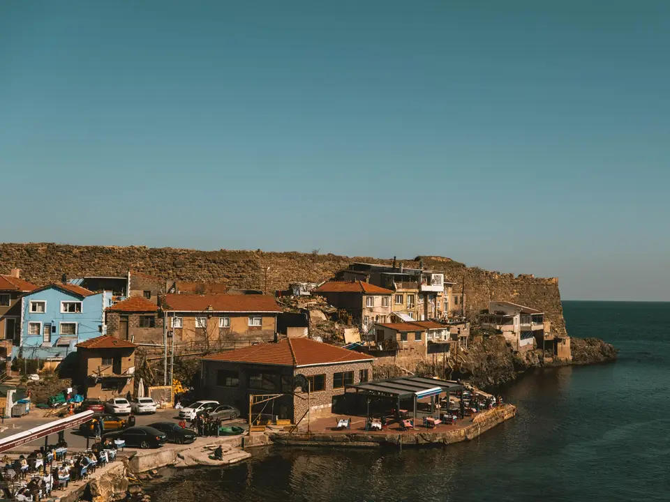 Stone village clinging to a sea cliff above the water