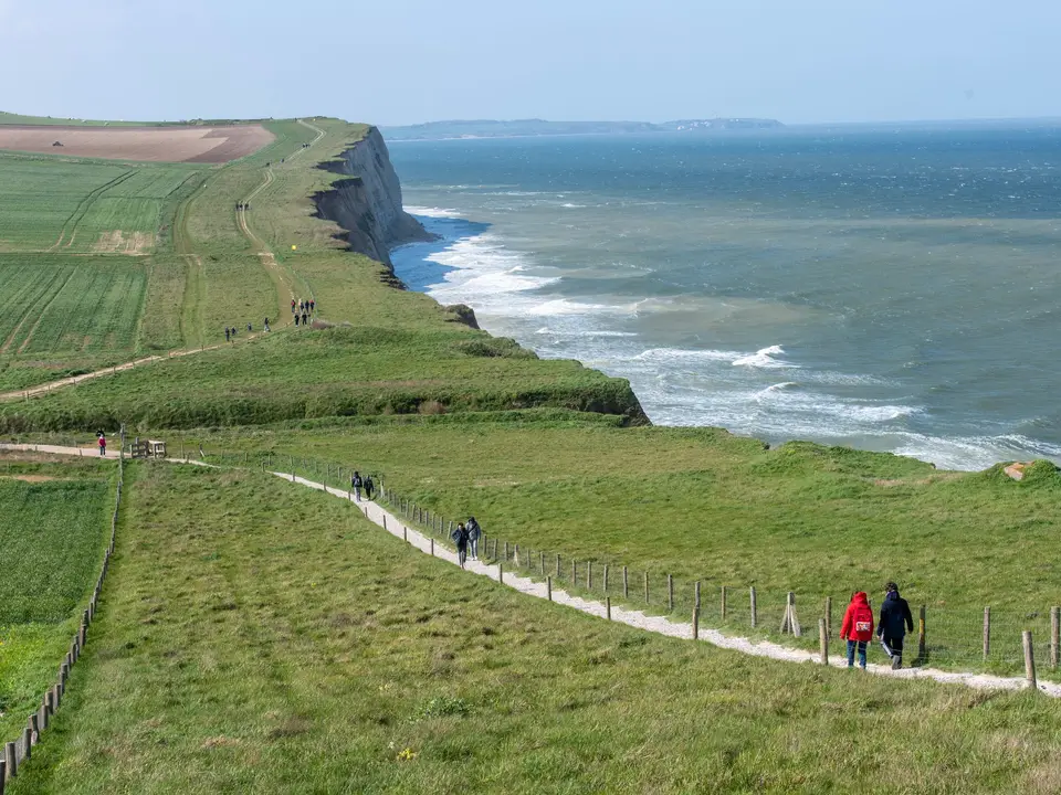 Walking path along green coastal cliffs above the sea