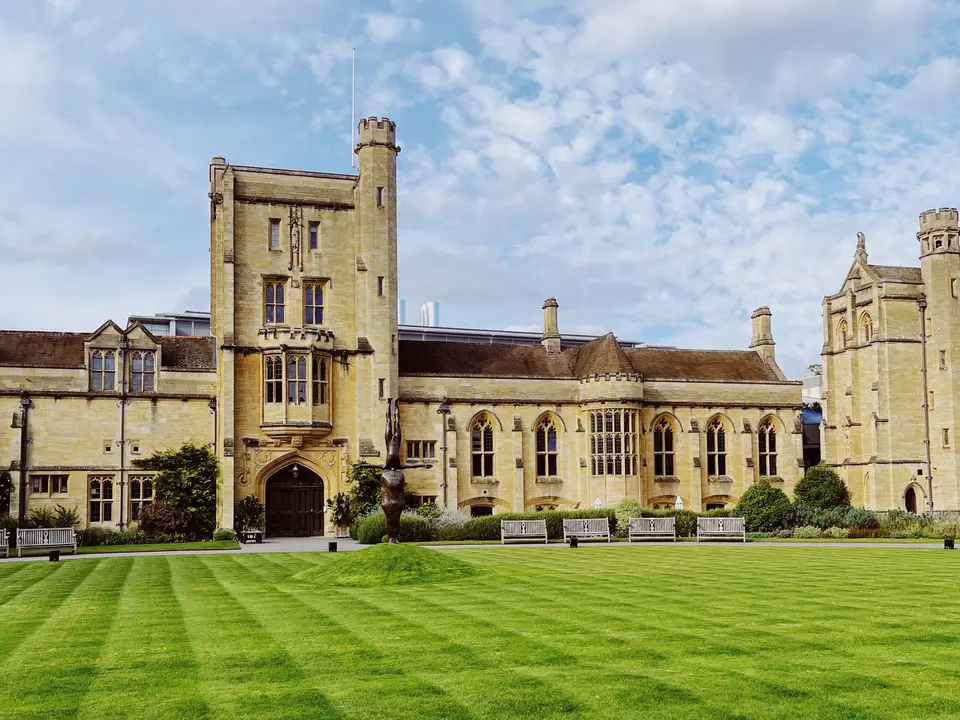 Historic university building with a green lawn