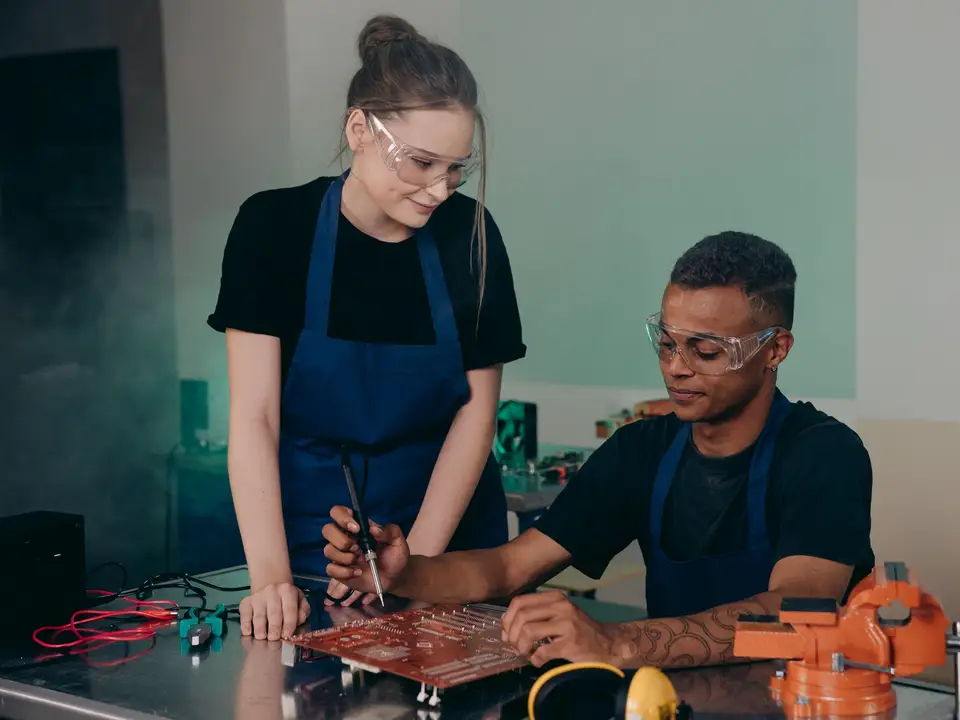 Two engineers working together on a circuit board