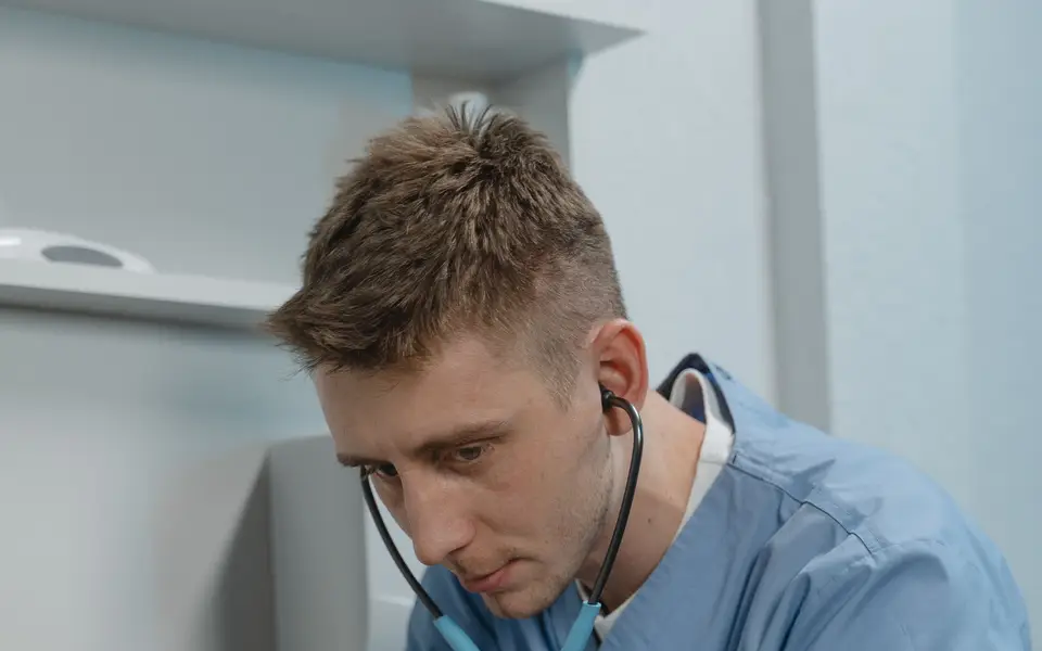 A veterinarian listening to a dog's chest with a stethoscope
