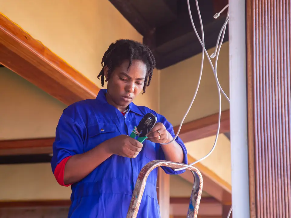 Electrician working on wiring on a ladder