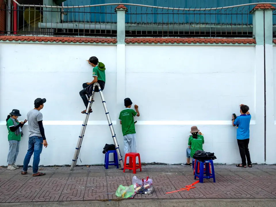 Volunteer group painting a community wall