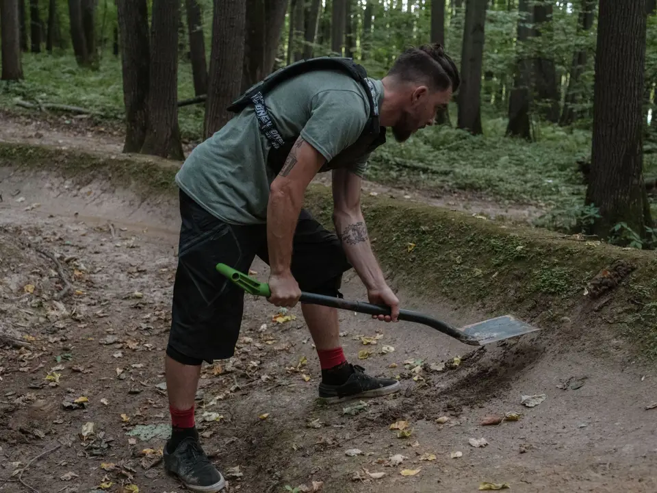 Volunteer digging to repair a forest trail