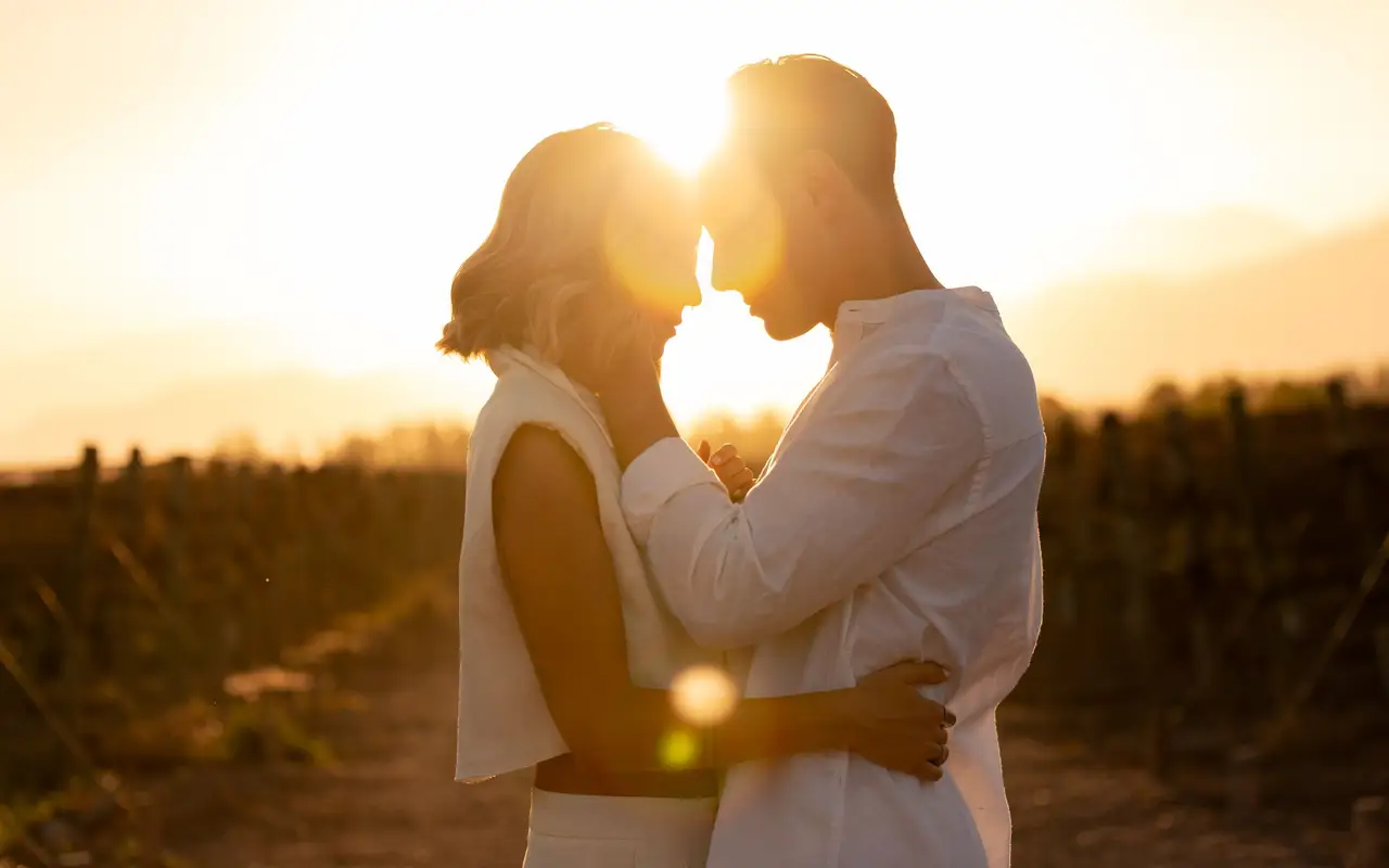 Couple embracing among vines at sunset