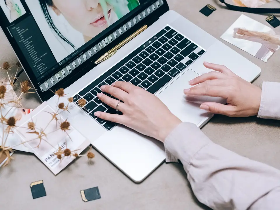 Camera and memory cards beside a laptop